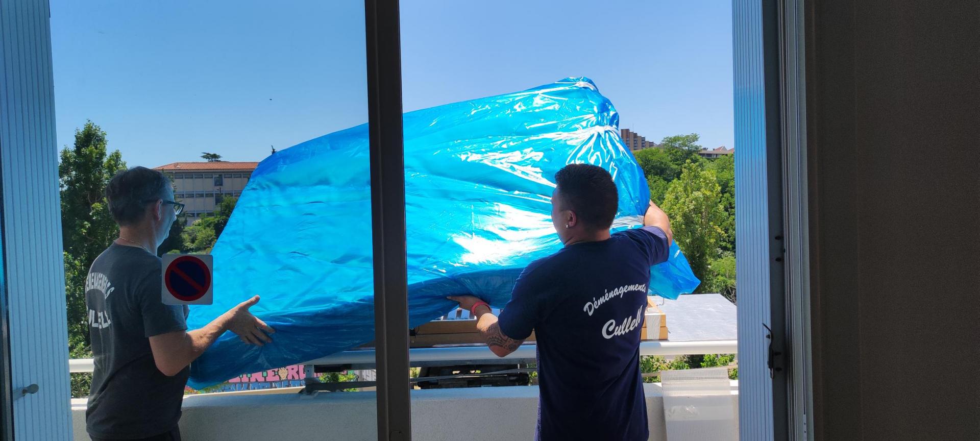 monte-meubles L'équipe de déménageurs mettent en place le mobilier sur la nacelle du monte-meubles